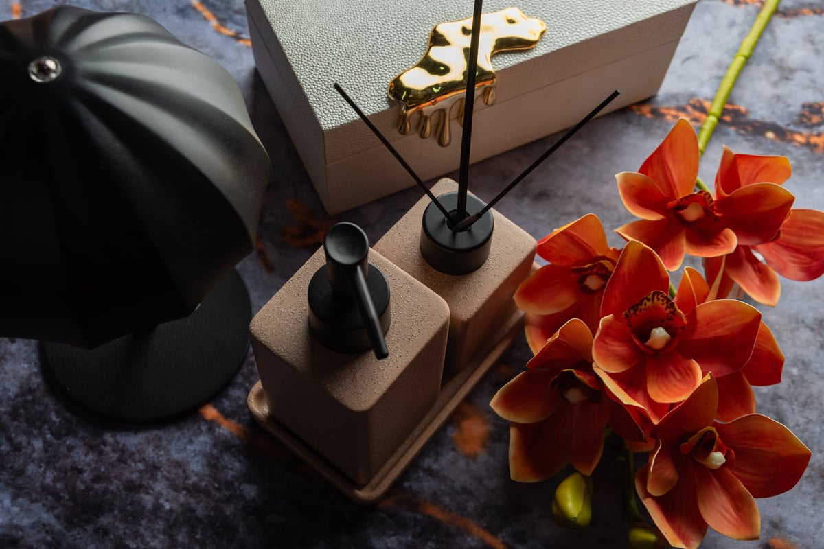 Dark moody beauty product still life with warm gold rim lighting